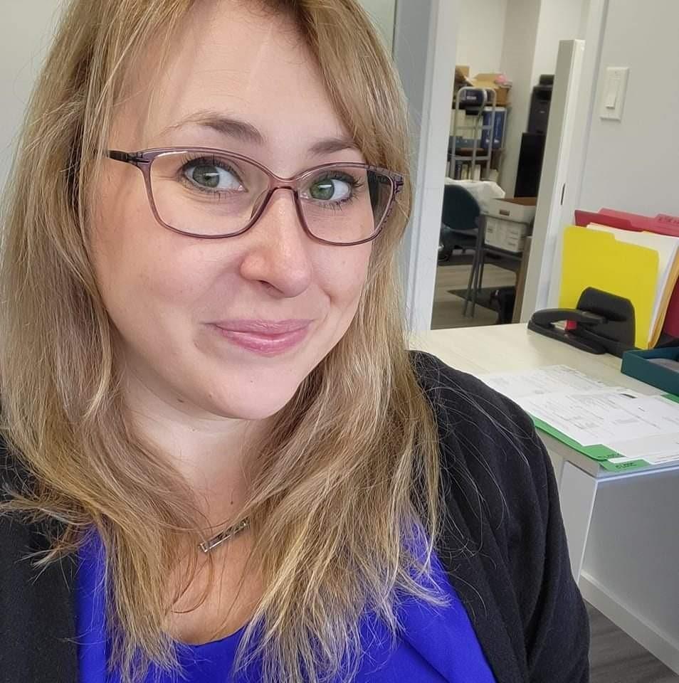 A smiling woman with blonde hair and glasses